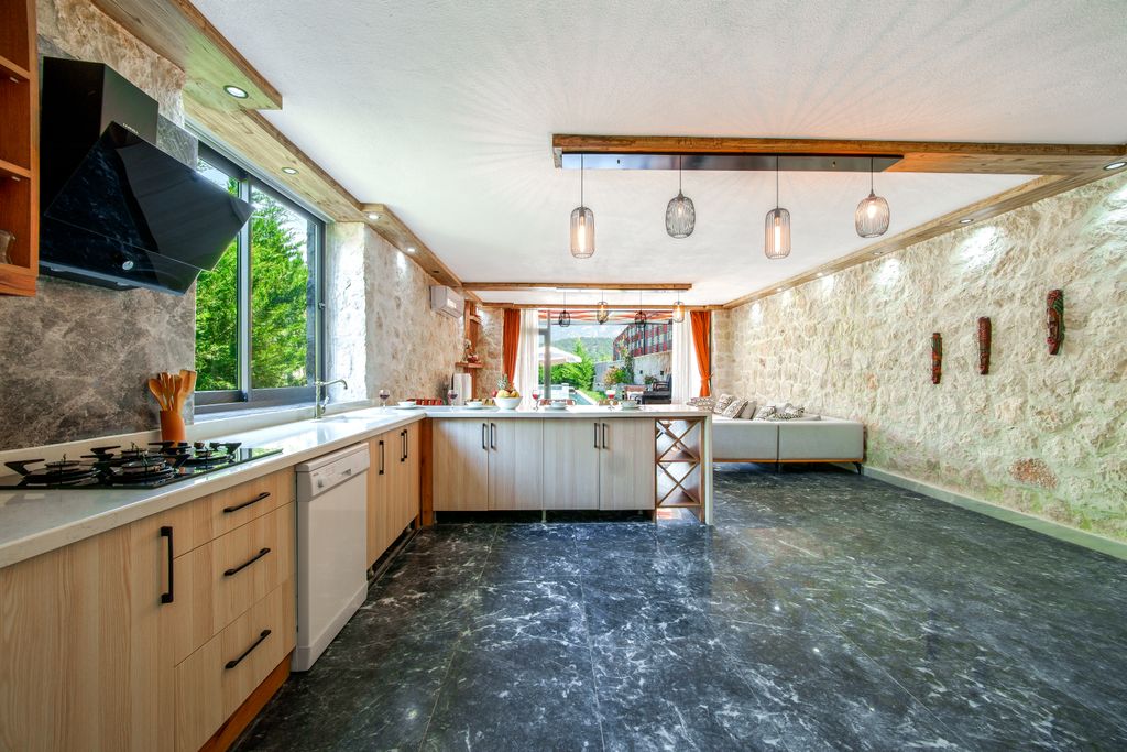 15 Kitchen Window Ideas to Brighten Your Space in Style Spacious kitchen with stone walls and modern appliances, featuring natural light.