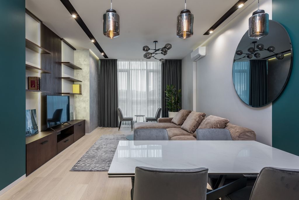 Small Living Rooms With TVs: 21 Stylish Ideas Dining table with chairs placed near comfortable couch and modern TV set in cozy living room decorated with mirror and lamps