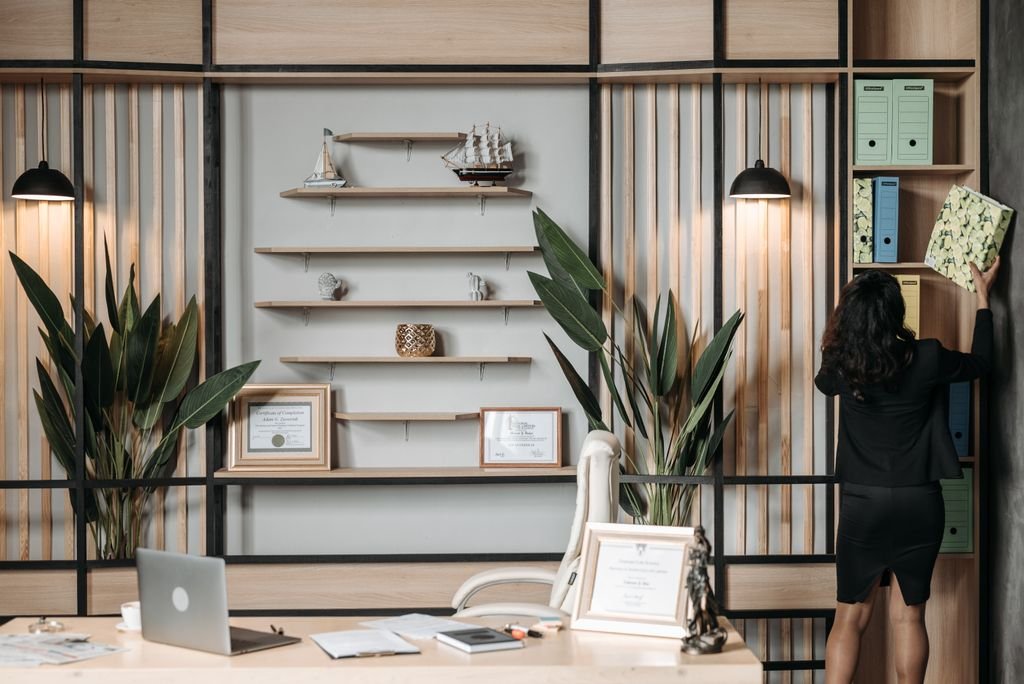 42 Shelf Decor Ideas for a Stylish, Balanced, and Clutter-Free Home Elegant office interior with a businesswoman organizing files on a shelf.